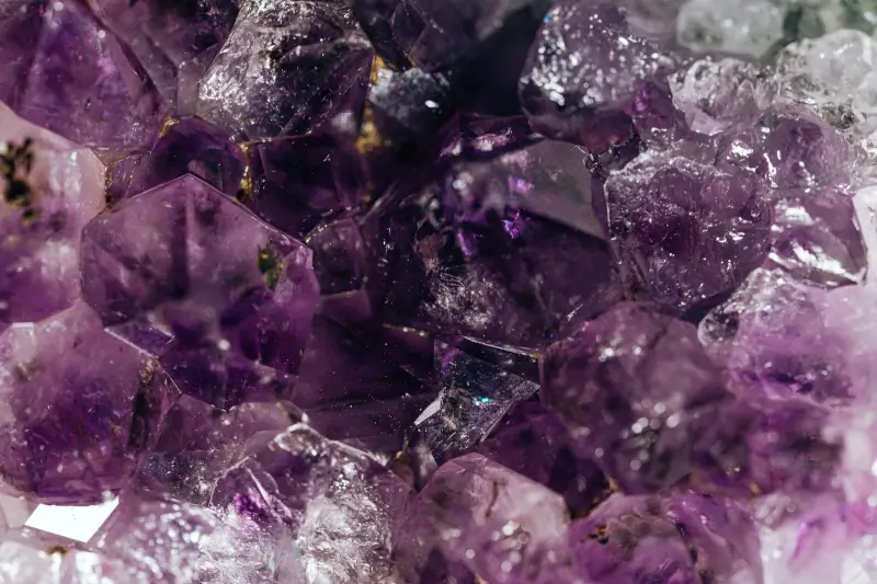 Violette Amethyst-Rohsteine als stilles Arrangement; neutrale Fläche, natürliche Struktur.