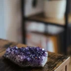 Mehrere Amethyst-Rohsteine als ruhiges Arrangement auf hellem Hintergrund; Produktfoto für Meditation und Achtsamkeit.