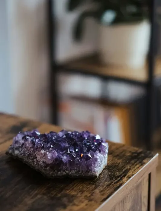 Mehrere Amethyst-Rohsteine als ruhiges Arrangement auf hellem Hintergrund; Produktfoto für Meditation und Achtsamkeit.
