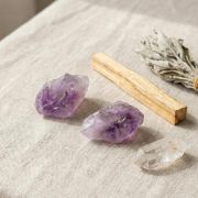 Detailaufnahme von naturbelassenen Amethyst Rohsteinen auf einem hellen Untergrund.