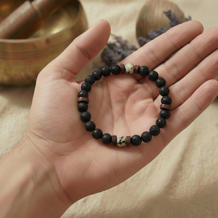 Hand mit Anti-Stress Armband aus Lava und Howlith für innere Ruhe.