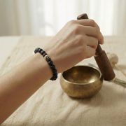 Hand mit Anti-Stress Armband und Klangschale zur Förderung von innerer Ruhe