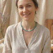 Frau trägt eine Chakra Kette mit echten Naturstein Perlen in Türkis, ideal für Yoga und Meditation.