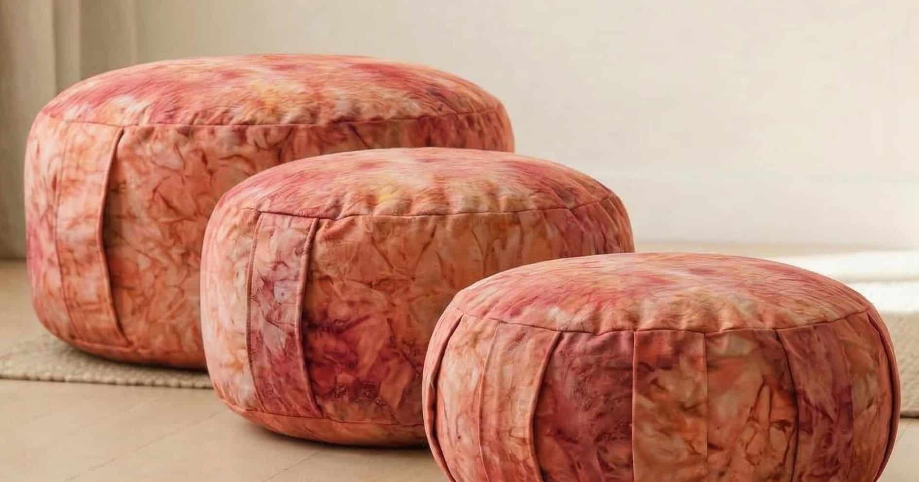 Detailansicht der verschienenen Meditationskissens – pflanzliche, vegane Färbung mit einzigartigen Nuancen in Bordeaux, Rot und Gelb, jedes Kissen ein Unikat, natürliche Pigmente aus Blättern und Wurzeln, sanfte chakren Farben für ruhigen Blick, nachhaltiges Material ohne tierische Bestandteile oder Chemikalien, perfekte Kombination aus Ästhetik, Funktion und spiritueller Tiefe.