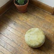 Gelbes Bio Meditationskissen auf Holzboden, ideal für Yoga und Meditation.