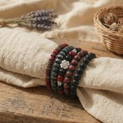 Holz Armband Set in erdigen Farben, präsentiert auf einem Leinentuch mit Lavendel im Hintergrund.