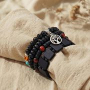 Holz Armband Set mit Baum-Anhänger auf einem Handgelenk, erdige Farben und Materialien.