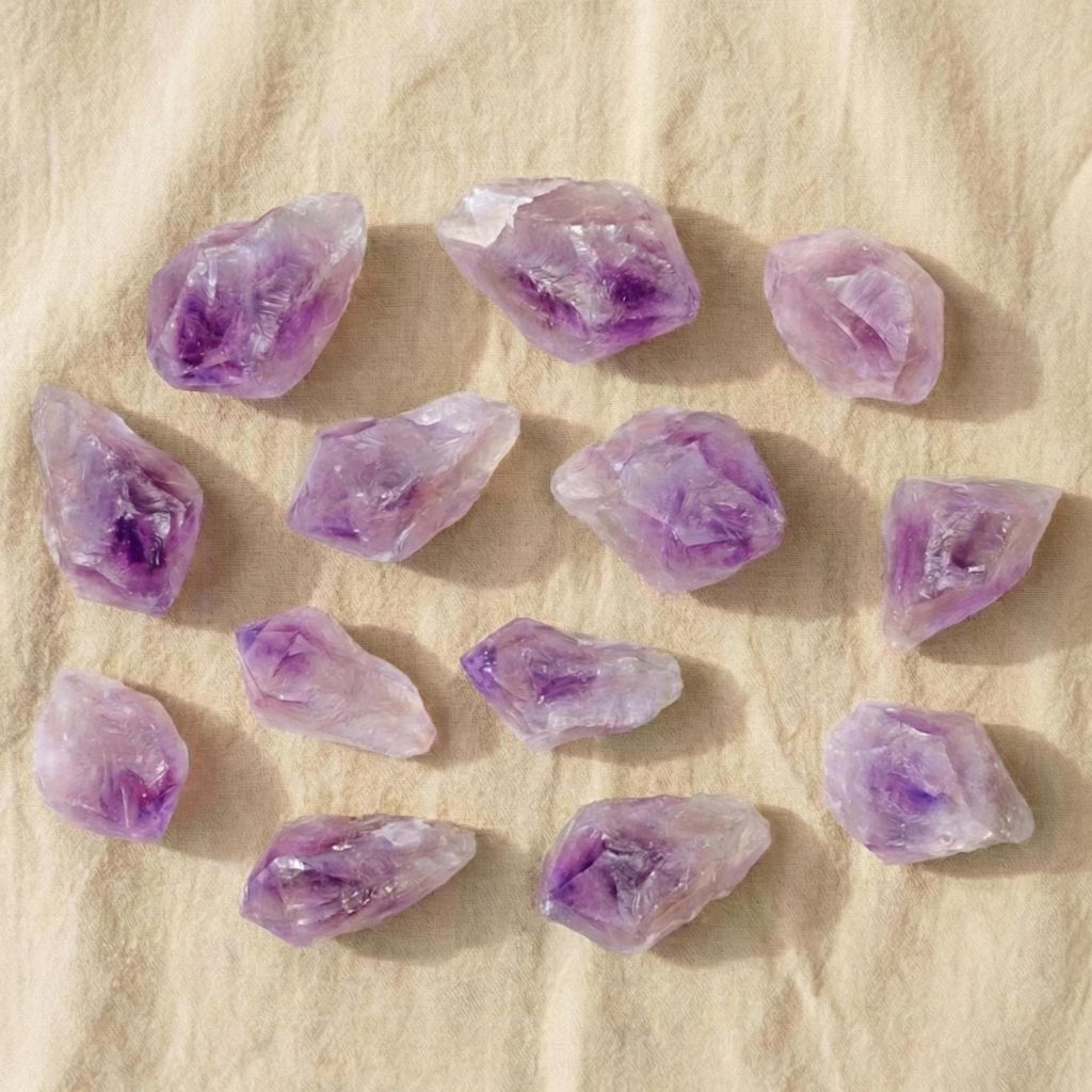 Rohstein aus violettem Amethyst auf hellem Hintergrund – naturbelassener Kristall zur Meditation, für Achtsamkeit und spirituelle Räume.