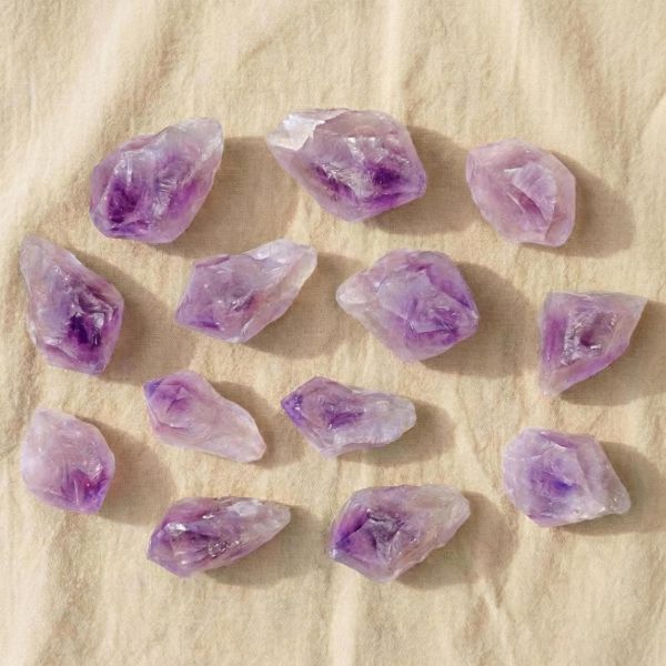 Rohstein aus violettem Amethyst auf hellem Hintergrund – naturbelassener Kristall zur Meditation, für Achtsamkeit und spirituelle Räume.