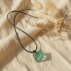 Detailaufnahme eines rohen Fluoritsteins mit natürlicher Oberfläche – grün, leicht transparent, individuell in Farbe und Struktur.