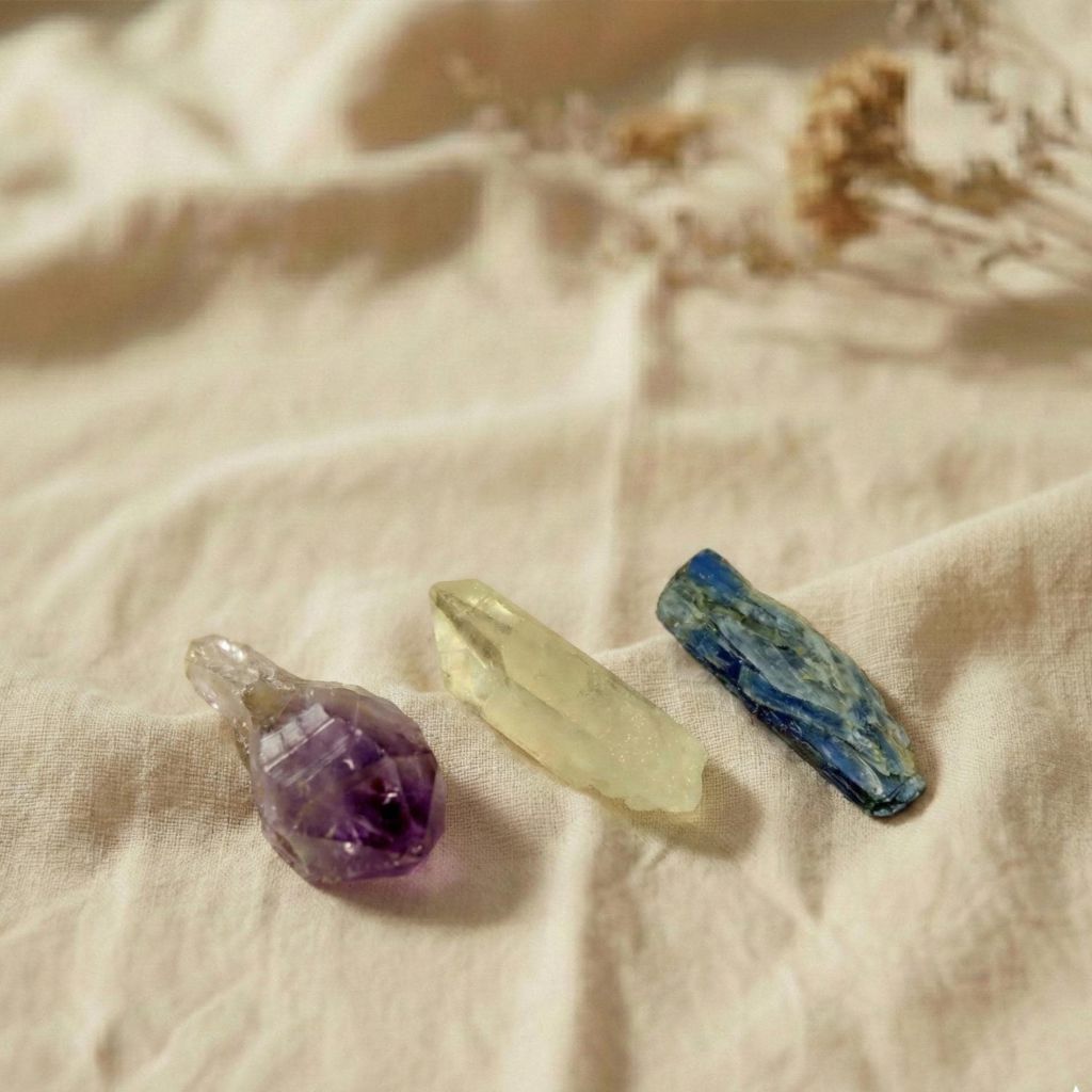 Achtsam arrangierte Rohkristalle Amethyst, Bergkristall und Blaukyanit auf Leinentuch – perfekte Begleiter für Meditation.