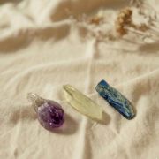 Achtsam arrangierte Rohkristalle Amethyst, Bergkristall und Blaukyanit auf Leinentuch – perfekte Begleiter für Meditation.