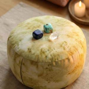 Kreativ-Kristalle arrangiert auf gelben Meditationskissen für kreative Meditation und Chakrenarbeit.