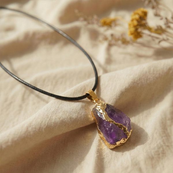Amethyst Anhänger mit goldener Fassung auf hellem Hintergrund