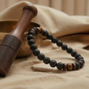 Das schwarz-braune Armband wird am Handgelenk eines Mannes getragen, kombiniert mit Freizeitkleidung.
