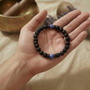 Lifestyle-Bild: Das Armband liegt neben einem Glas Wasser und einem Laptop (Thema Fokus bei der Arbeit).