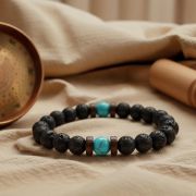 Detailansicht der porösen Struktur der schwarzen Lavasteine und der glatten Türkisperlen.