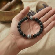 Das Armband liegt neben einer Meditationsschale und zeigt die elastische Struktur.