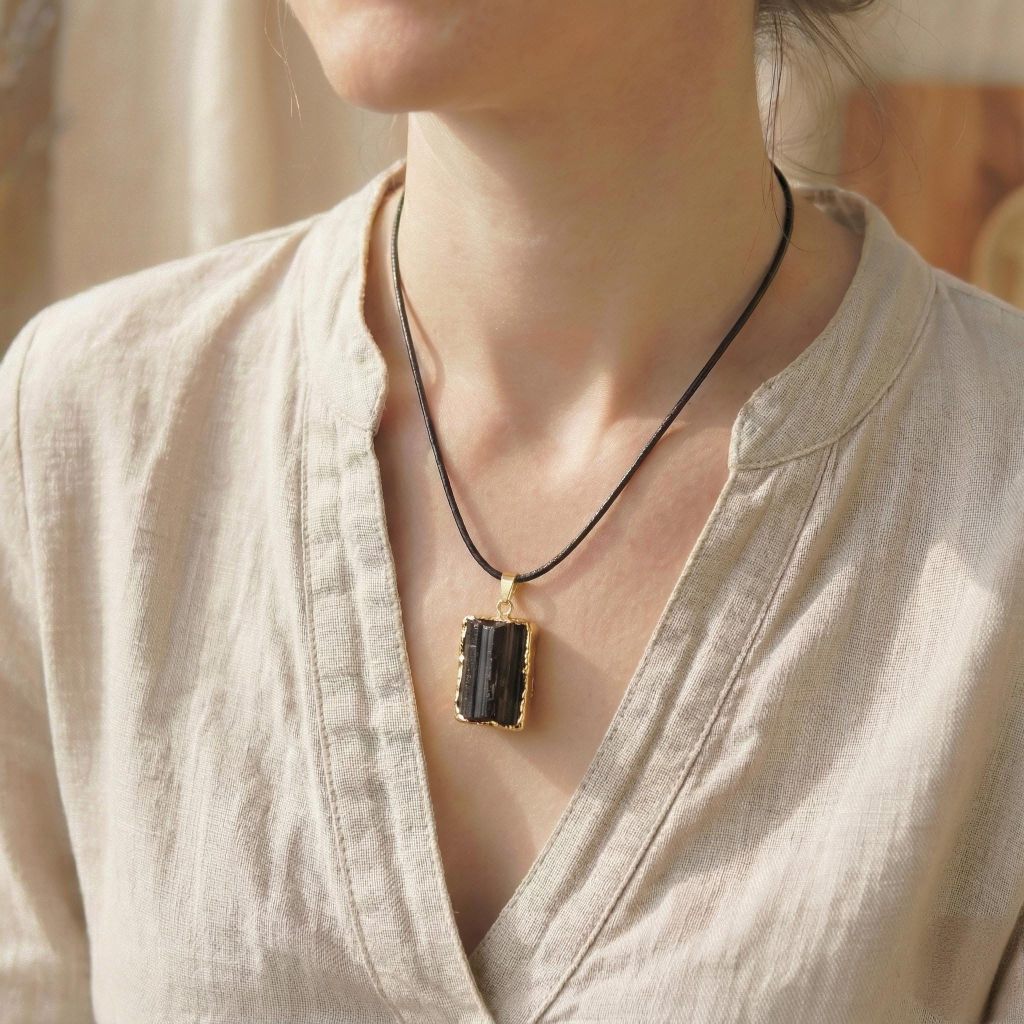 Der schwarze Turmalin-Anhänger getragen an einem Dekolleté, zeigt die Größe und Proportion.