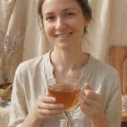 Makroaufnahme des rohen Labradorit-Natursteins, der an der goldenen Kette befestigt ist und sein charakteristisches, irisierendes Farbspiel in Blau- und Grüntönen zeigt.