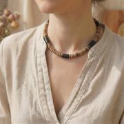 Chakra-Kette aus natürlichem Kokosholz dekorativ auf Naturleinen – bewusster Schmuck für Achtsamkeit & Balance, plastikfrei verpackt.