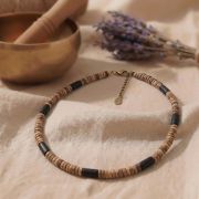 Kokosholz-Kette mit schwarzen Holzperlen auf einem weichen Untergrund.