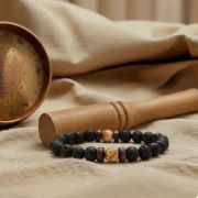 Detailaufnahme des Lava Armbands mit Bildstein und Naturstein Perlen auf einem weichen Untergrund.
