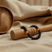 Detailaufnahme des Lava Armbands mit Honig Calcit Perlen auf einem Holzuntergrund.
