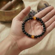 Lava Armband mit Honig Calcit in Hand gehalten, zeigt die natürliche Struktur und Farben.