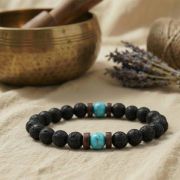 Lava Armband mit Türkis und Naturstein Perlen auf einem Tisch mit Lavendel und einer Schale.