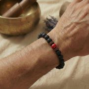 Detailaufnahme eines Lava Armbands mit rotem Jaspis auf einem Handgelenk.