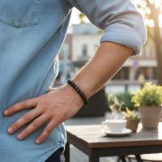 Lava Armband aus schwarzen Natursteinperlen, getragen am Handgelenk in natürlicher Umgebung.