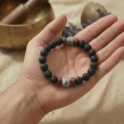 Hand mit Lavastein und Howlith Armband, zeigt die Struktur und Farben der Perlen.