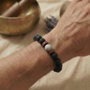 Detailaufnahme eines Lavastein Armbands mit Howlith auf einem Handgelenk