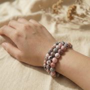 Rosa Zebra Jaspis Armband auf Hand, zeigt die sanften Rosatöne und die charakteristische Maserung.