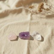 Nahaufnahme von Rosenquarz, Amethyst und Bergkristall auf einem hellen Hintergrund.
