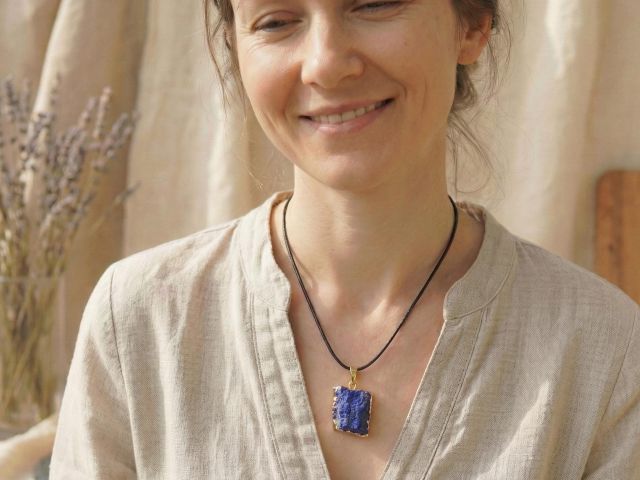 Frau trägt eine Lapislazuli Kette mit goldenen Akzenten, die minimalistisch und elegant wirkt.