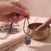Detailaufnahme der Amethyst Kette mit Türkis Anhänger in der Hand gehalten.