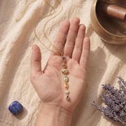 Chakra Halskette Gold mit 7 Steinen in Hand gehalten, symbolisiert innere Balance.