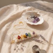 Chakra Selenit Kette Anhänger auf einem Tisch mit Natursteinen und Lavendel.