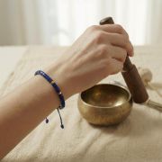 Lapis Lazuli Armband in Heishi-Form, getragen an einer Hand, mit einer Schale im Hintergrund.