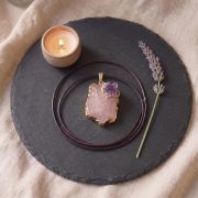 Rosenquarz und Amethyst Anhänger auf einer Schieferplatte mit Kerze und Lavendel